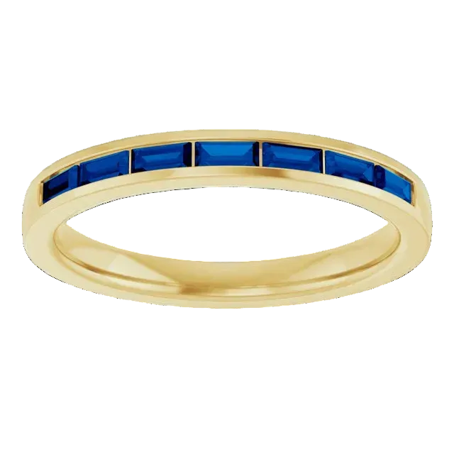 Gold ring with blue gemstones on a white background
